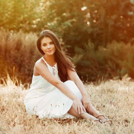坐在草地上的白裙美女图片