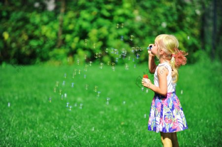 草坪上吹泡泡的女孩图片