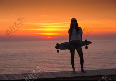 海边拿着滑板的女孩图片