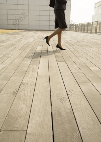 行走在木地板上的商务女性图片