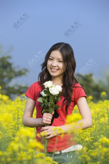 油菜花丛中的漂亮女大学生图片图片