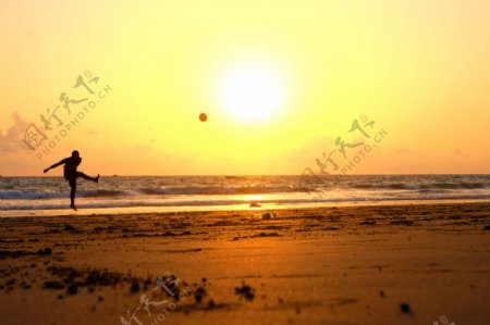 海边踢足球男子图片