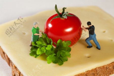 面包上推着西红柿的工人图片