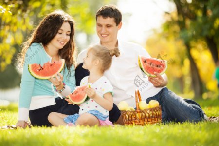 草地上吃西瓜的家庭图片