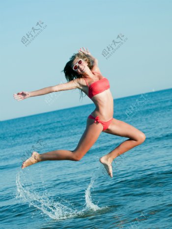 海边跳跃的比基尼美女图片
