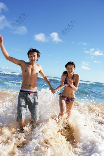 海边玩耍的情侣摄影图片