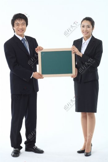 手拿小黑板展示的商务男女图片