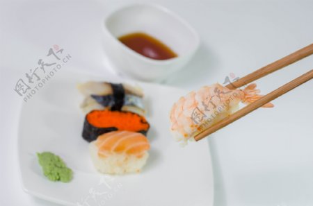 筷子夹起的寿司图片