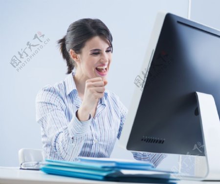 电脑前握拳的美女图片