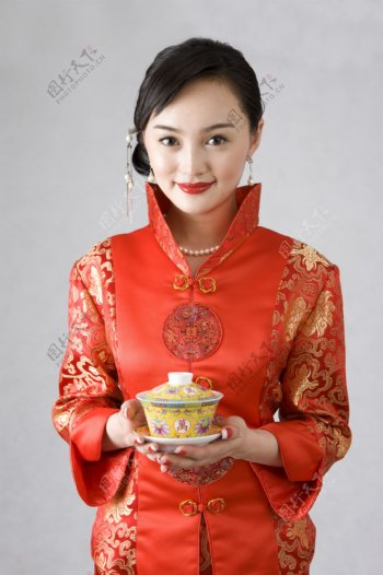 双手托茶杯的旗袍女人图片