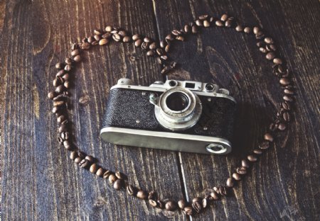 木板上的心形咖啡豆与相机图片