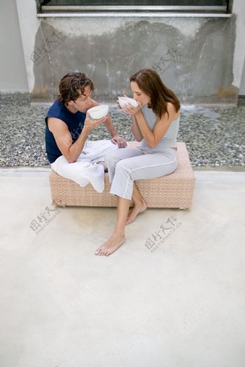 大水池旁坐着喝水的外国情侣图片
