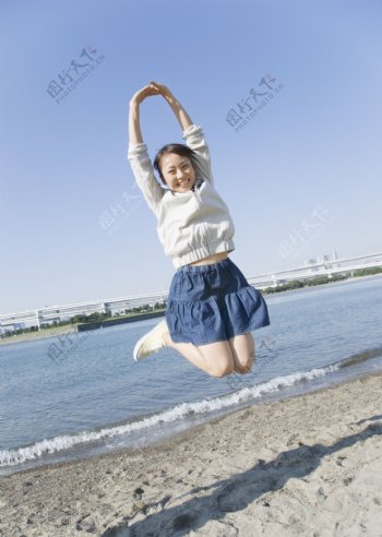 沙滩跳跃的快乐女生图片