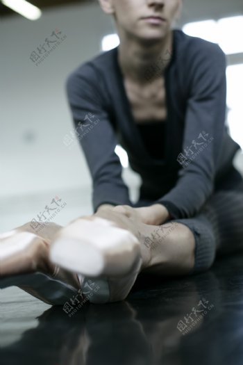 正在压腿的女性舞蹈演员图片