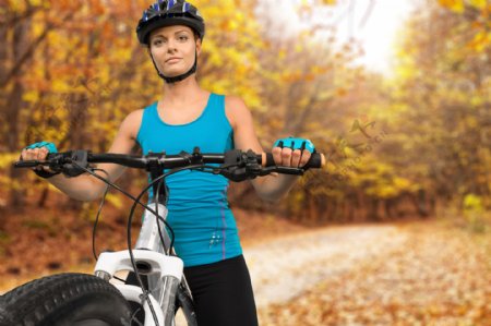 枫树林推着自行车的运动美女图片