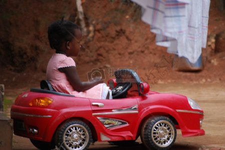 坐在红色玩具汽车的小孩