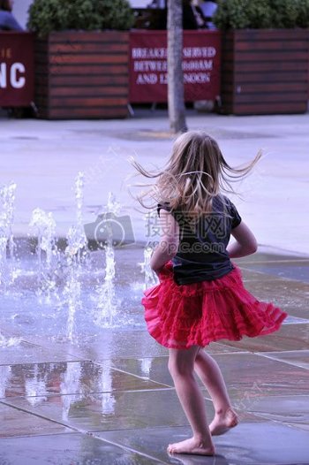 喷泉前嬉戏的小女孩
