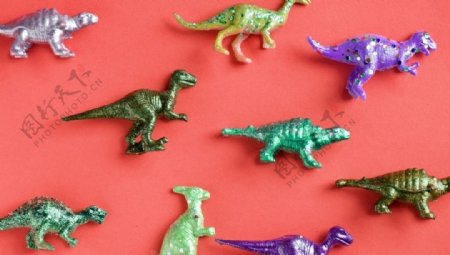 红色表面上的五颜六色的玩具恐龙
